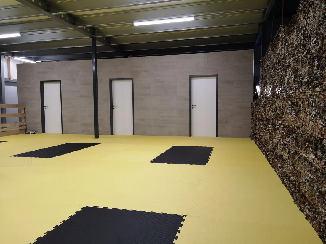 Große, helle Indoor-Trainingshalle mit gelbem Boden